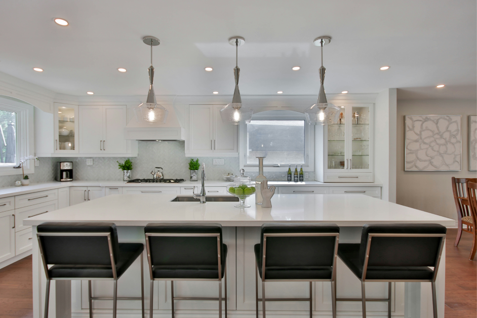 A kitchen with white cabinets and black chairs